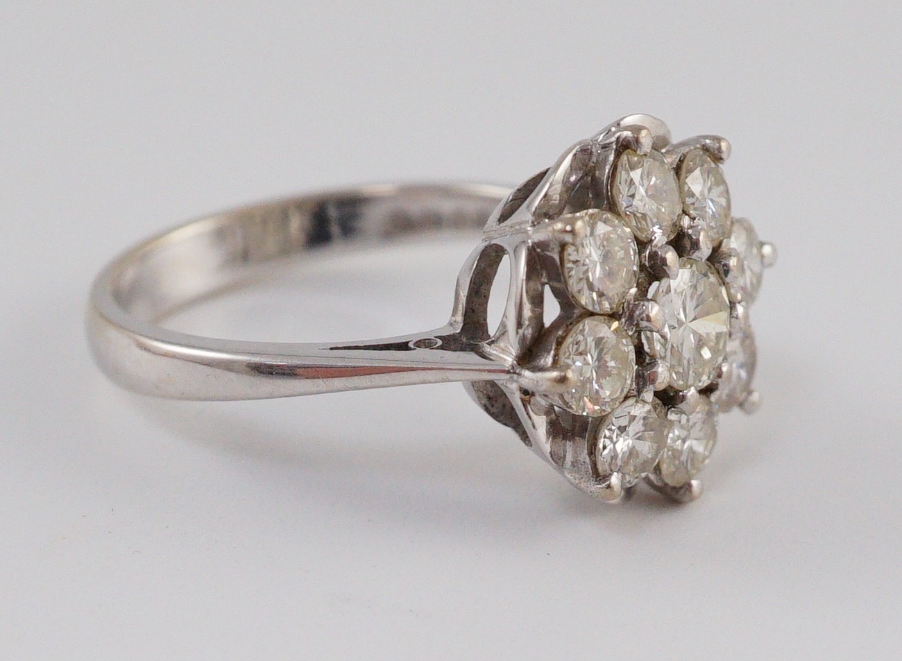 A modern 18ct white gold and nine stone diamond illusion set circular cluster ring